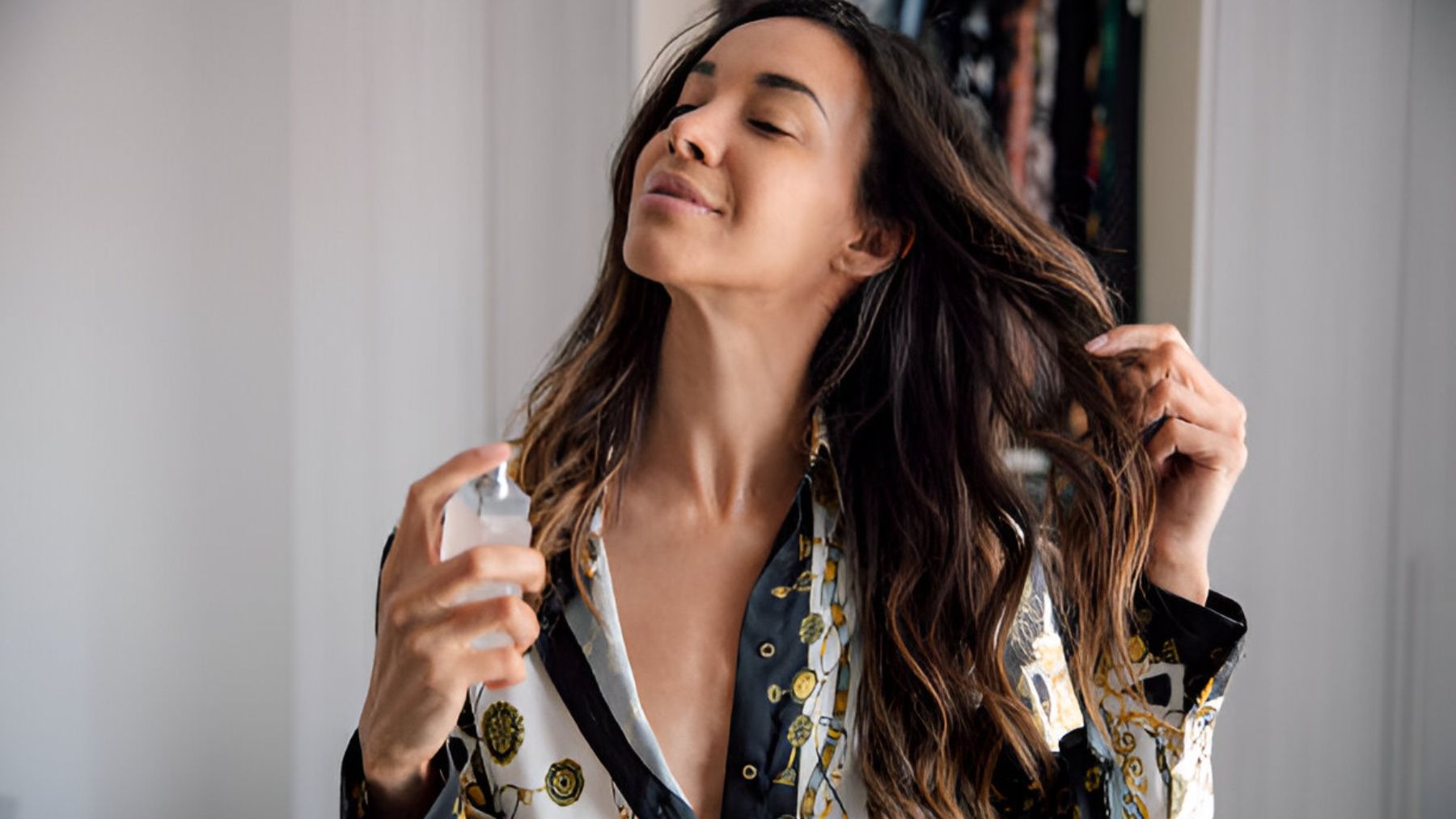 Mujer perfumándose.